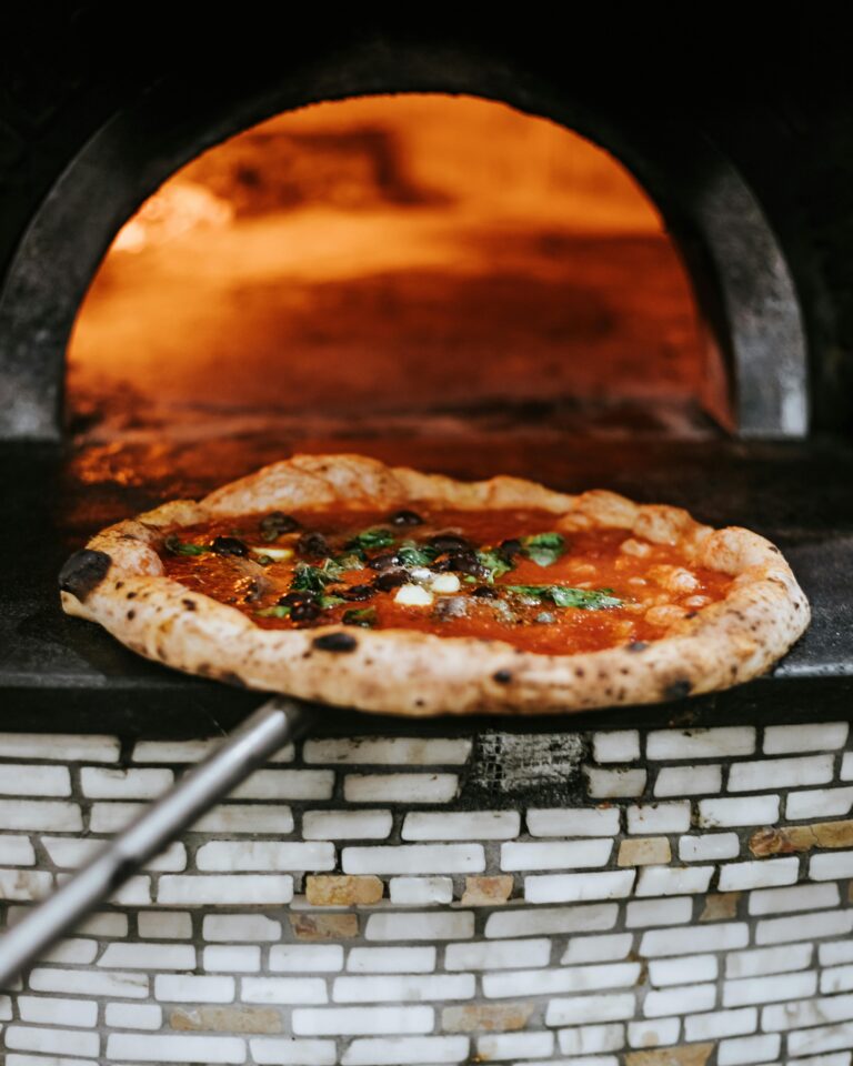 Freshly baked Neapolitan pizza emerging from a wood-fired oven in Naples.